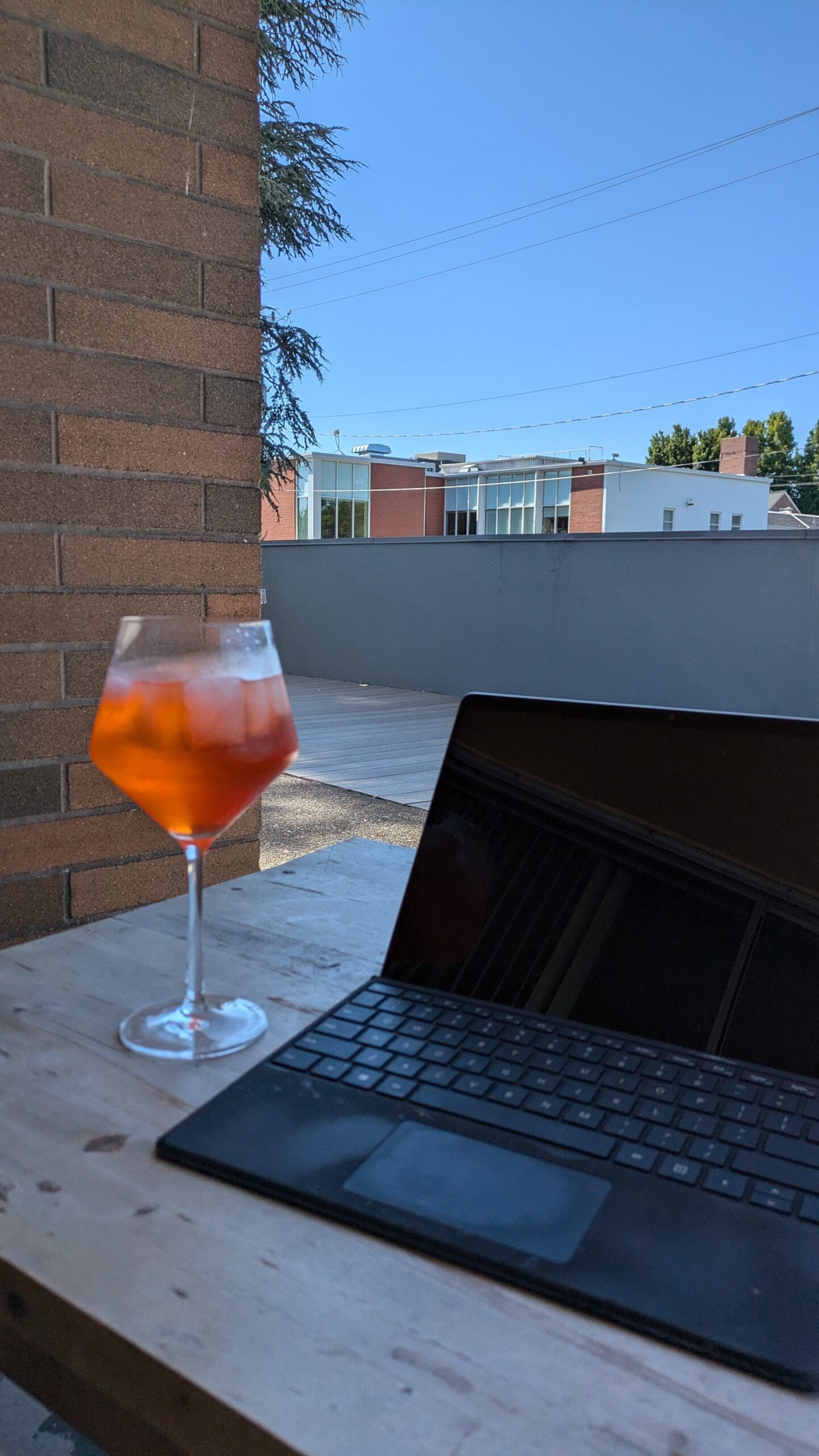 cocktail and laptop. travel agent marketing tips and strategies.